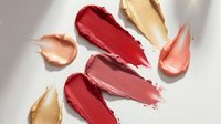 Colorful lipstick smears and swatches in red pink coral and nude shades on white background for makeup beauty cosmetics advertising and design projects.