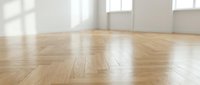 Empty room interior with polished wooden parquet flooring and white walls with natural sunlight streaming through windows creating bright spacious atmosphere.