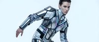 Young male with light skin tone and dark hair wearing futuristic metallic armor suit with geometric patterns, posed in dynamic action stance against white background for sci-fi and gaming concepts.