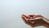 Open cupped hands in receiving gesture against clean white background for wellness and spiritual concepts.