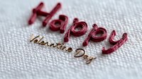 Red metallic Happy Valentine Day text on white textured background with selective focus creating romantic greeting card design element.
