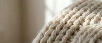 Close-up of natural beige rope coils with detailed fiber texture, perfect for nautical themes, crafting projects, and rustic home decor applications.