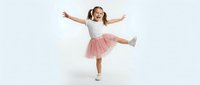 Happy young girl in pink tulle skirt and white top dancing with arms outstretched on white background. Joyful child expressing freedom and movement.
