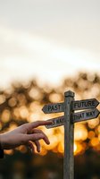 Hand pointing at wooden directional signpost with past future options at golden hour sunset with bokeh lights for life choices and decision making.
