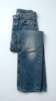 Folded blue denim jeans with vintage wash and faded details on white background, casual menswear fashion apparel isolated for clothing design.