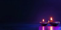 Glowing diya lamps with burning flames on dark purple background with reflection, traditional festive spiritual celebration atmosphere.