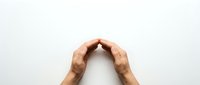Cupped hands forming a protective arch gesture on white background, symbolizing care, safety, and support for insurance or charity concepts.