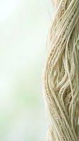 Flowing blonde hair strands with soft highlights on pastel background for beauty and haircare concepts.