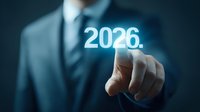 Businessman in dark suit pointing at glowing 2026 number floating in dark space, representing future business planning and digital transformation concept.