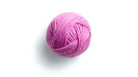 Pink wool yarn ball isolated on white background, ready for knitting and craft projects. Soft textile material for handmade accessories and clothing.