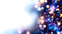 Magical holiday bokeh lights with blue and pink glowing defocused circles creating dreamy festive atmosphere against dark background.