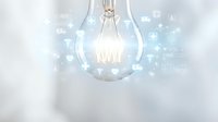Glowing light bulb with digital network connections and data icons floating around representing innovation, technology and creative ideas in business.
