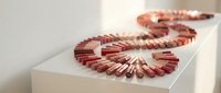 Copper coil inductors arranged in spiral formation on white surface for electronics manufacturing and electrical engineering applications.