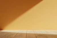 Empty wooden table surface against orange wall with dramatic diagonal shadow, minimalist background for product display and presentation.