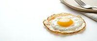 Crispy fried egg with golden yolk on white background, isolated breakfast food ready for cooking designs and culinary projects.
