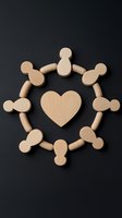 Wooden figures arranged in circle around heart shape on dark background symbolizing unity, community support and teamwork concept for social projects.