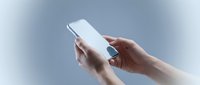 Hands holding white smartphone with blank screen on gradient background for mobile app mockup and digital technology presentations.