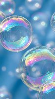 Colorful soap bubbles floating against soft blue background with rainbow reflections and bokeh light effects for dreamy artistic designs.