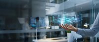 Male professional holding a glowing holographic building blueprint in a modern office, showcasing smart architecture and digital construction planning.