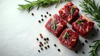 Fresh raw beef tenderloin steaks with rosemary sprigs and peppercorns on white background, ready for cooking. Food photography for restaurant menu.
