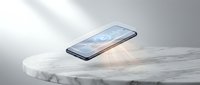 Modern smartphone with blue screen display floating above white marble pedestal surface with soft natural lighting and minimalist aesthetic for tech presentations.