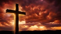 Wooden cross silhouetted against dramatic orange and red sunset sky with storm clouds for religious and spiritual themes.