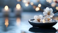Delicate white cherry blossoms floating in black ceramic bowl with water, soft bokeh lights in background creating zen atmosphere for spa and wellness concept.