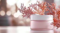 Pink cosmetic cream jar with coral branch decoration on blurred background with bokeh lights, luxury skincare product photography for beauty industry.