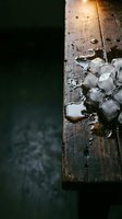 Melting ice cubes on weathered wooden surface with dark moody background, suitable for beverage, cooling, and refreshment concepts.