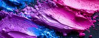 Vibrant crushed makeup pigments in pink, purple and blue shades creating abstract textured pattern with powder particles and smeared cosmetic swatches.
