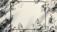 Minimalist black frame surrounded by delicate tree branch shadows cast on white wall, creating natural abstract composition for modern interior design.