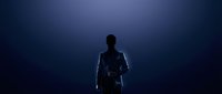 Silhouette of male professional in business suit standing against dark blue gradient background, rear view, corporate leadership and success concept.