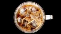Iced coffee with cream swirls in a glass mug, top view, isolated on transparent background. Ready for cafe menus, stickers, t-shirt design, and print on demand.