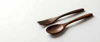 Handcrafted wooden spoon and fork set made from natural wood, isolated on white background for kitchen utensil designs and culinary projects.