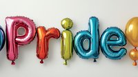 Colorful pride text spelled with metallic foil balloon letters in rainbow colors against white wall, celebration and equality concept for LGBTQ+ community events.