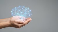 Human hands holding glowing blue network connections representing digital technology, artificial intelligence, and modern communication systems.