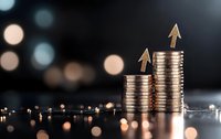 Growing stacks of silver coins with upward arrows showing financial growth and investment success against dark background with bokeh lights.