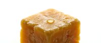 Closeup of golden caramel fudge candy with glossy surface and granulated sugar coating, suitable for food photography, confectionery advertising, and dessert packaging design.