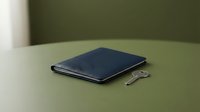 Dark blue leather wallet with metal key on sage green surface, suitable for finance, savings, and lifestyle design projects.
