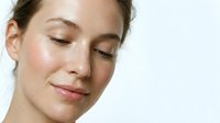 Young Caucasian woman with natural makeup and glowing skin, eyes closed in peaceful expression, skincare and beauty concept for wellness advertising.