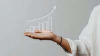 Female hand with bracelet holding digital growth chart with upward trend arrow against gray background, concept of business success and financial progress.