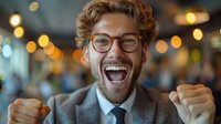 Excited young Caucasian businessman in glasses and grey suit celebrating success with energetic victory gesture against blurred bokeh background, expressing joy and achievement.