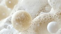 Delicate soap bubbles in soft beige and white tones create dreamy macro composition with spherical shapes and foam texture for spa and wellness designs.