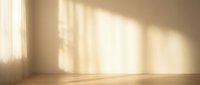 Empty room interior with warm sunlight streaming through window creating shadow patterns on beige wall and wooden floor for home design projects.