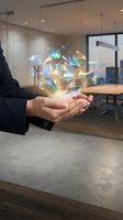 Businesswoman holding glowing holographic house with financial data in modern office environment, representing real estate investment and property technology solutions.