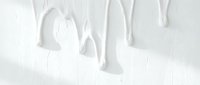 White paint dripping down textured wall surface creating artistic flowing patterns for interior design and creative projects.