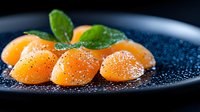 Fresh salmon sashimi slices garnished with basil leaves and black caviar on dark plate, close up view with water drops, luxury restaurant serving.