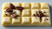 White chocolate bar with roasted coffee beans on top, creating a sweet and bitter contrast for dessert recipes and gourmet food photography.