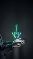 Businessman hands presenting glowing green spine hologram on dark background for medical technology and healthcare innovation concepts.
