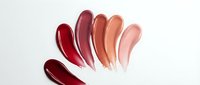 Colorful lipstick swatches in red, burgundy, coral and pink tones on white background. Beauty cosmetics makeup palette for branding and advertising.